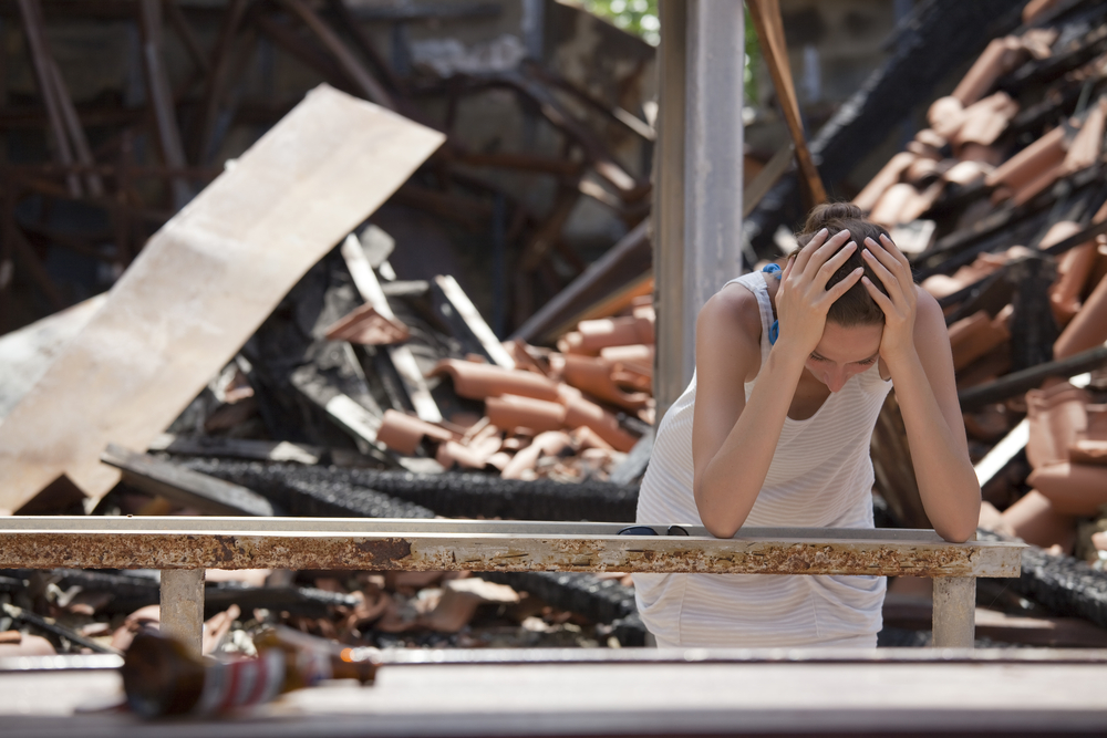sad woman and destroyed house